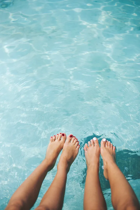Legs of a two female friends in the water